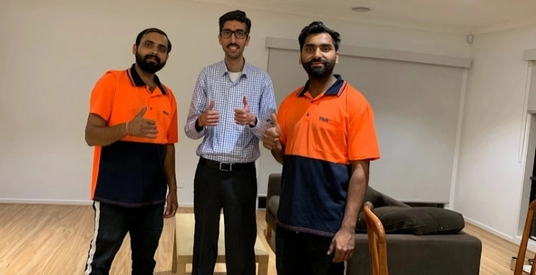 Harry The Mover's house removalists in Melbourne giving thumbs up with satisfied customer after successful home move, demonstrating trusted movers Melbourne service in orange and navy uniforms.